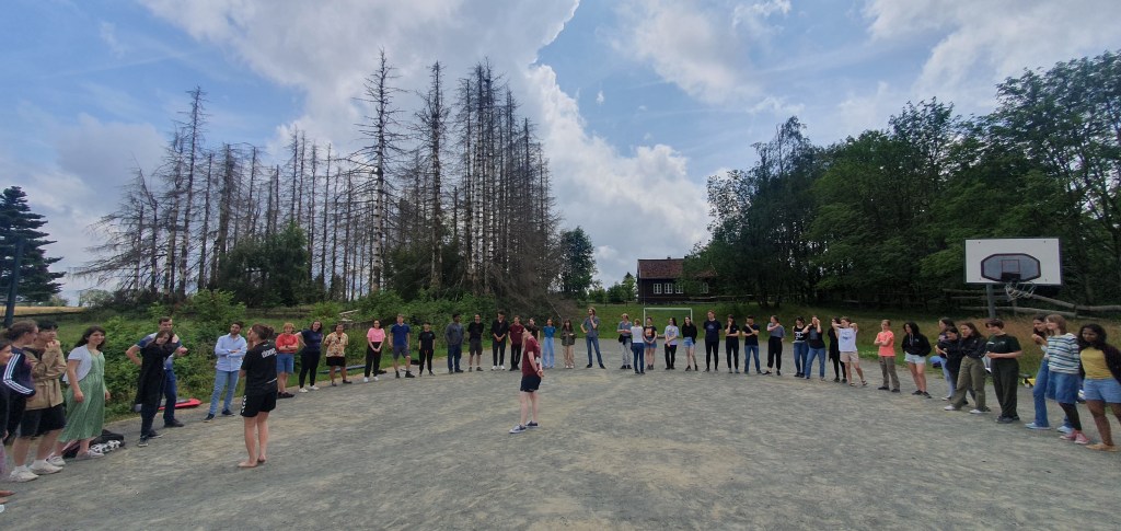 me standing at the centre of a circle of young astronomers, on a sandy football pitch in Germany.
