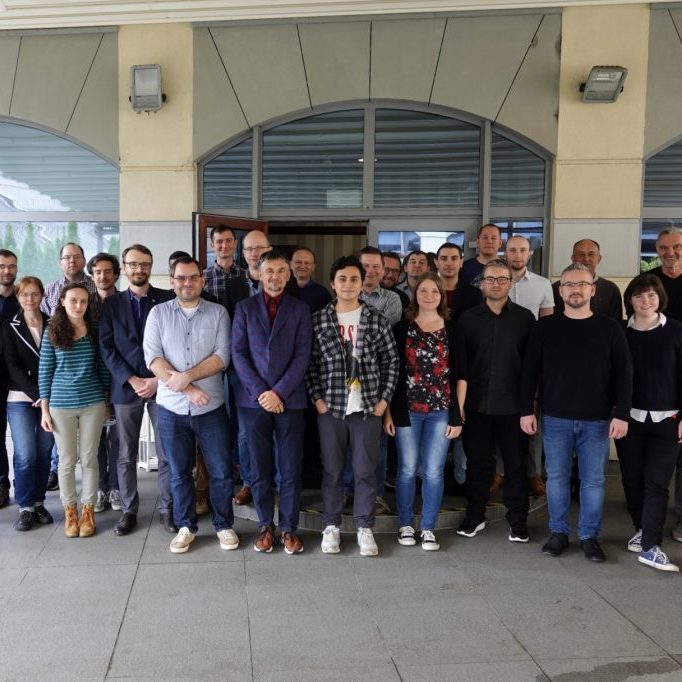 group photo of scientists in front of a hotel conference room