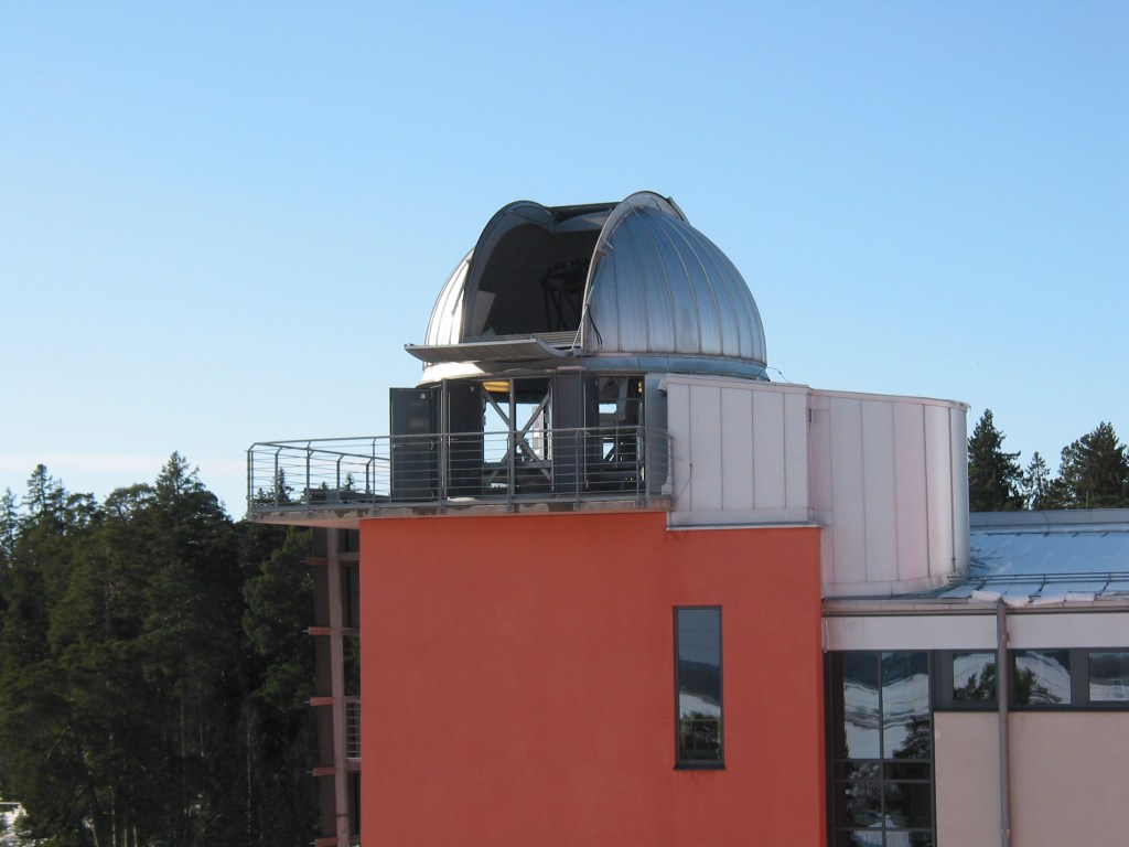 open telescope dome on the top of a building, with clear blue sky